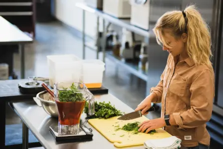 5f347199a5baeb0cd3f46a55 shannon waters gastro gnome founder in kitchen chopping fresh herbs