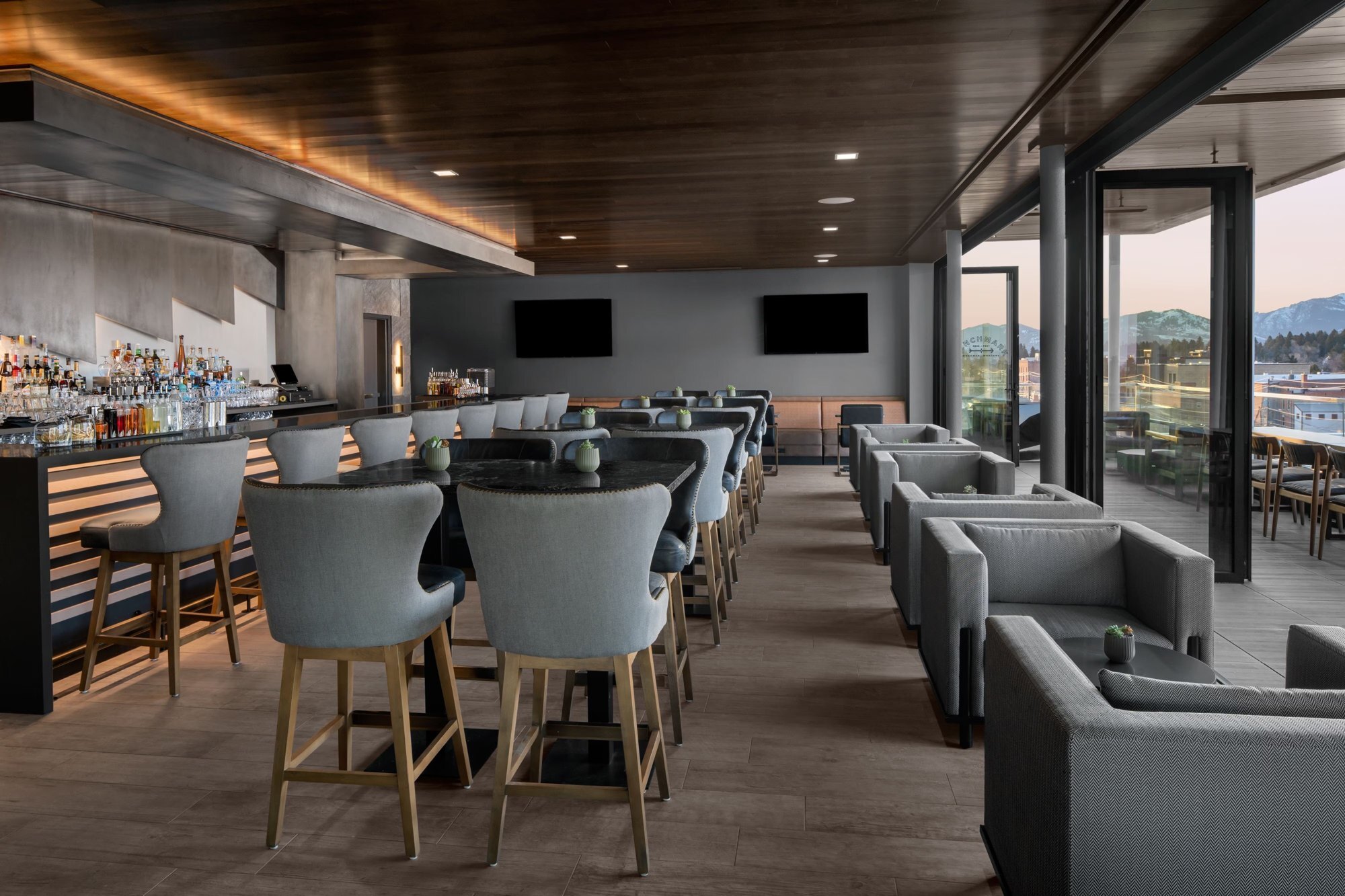AC Benchmark rooftop bar in downtown Bozeman with the deck and mountains at dusk